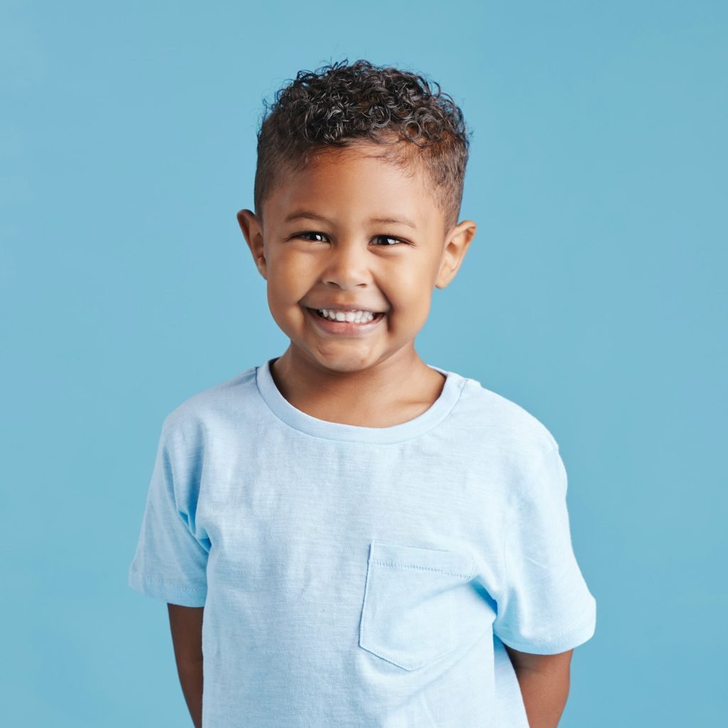 Portrait of a smiling little brown haired boy looking at the camera. Happy kid with good healthy te